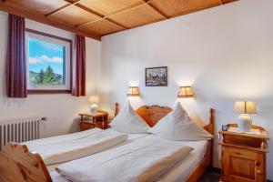 a bedroom with two beds and a window and two lamps at Ferienhaus im Grund in Hinterzarten