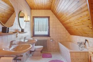 a bathroom with two sinks and a tub and a toilet at Ferienhaus im Grund in Hinterzarten +106 photos