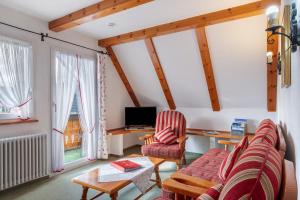a living room with a couch and two chairs and a tv at Ferienhaus im Grund in Hinterzarten
