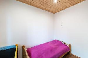 a bed in a room with a white wall at Moderner Bungalow, rollstuhlgerecht in Warnow