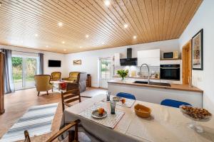 a kitchen and living room with a table and chairs at Moderner Bungalow, rollstuhlgerecht in Warnow