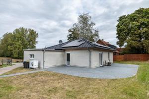 a small white house with a large driveway at Moderner Bungalow, rollstuhlgerecht in Warnow