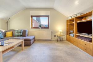 a living room with a couch and a tv at Mill Nordkirchen in Nordkirchen