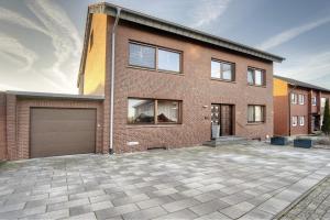 a brick house with a garage in front of it at Mill Nordkirchen in Nordkirchen