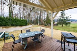 a patio with a table and chairs on a deck at Gite Prairie in Aubas