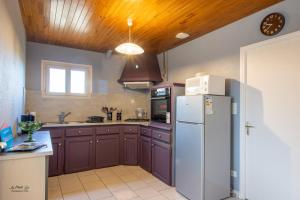 a kitchen with brown cabinets and a white refrigerator at Gite Prairie in Aubas