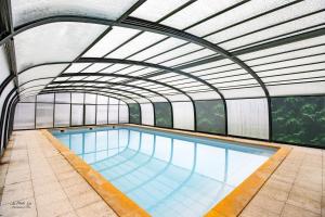 an indoor swimming pool with an overhead ceiling at Gite Prairie in Aubas
