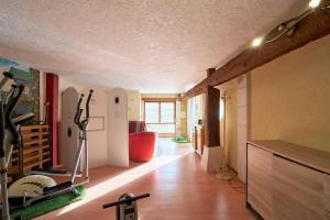 a room with a gym with a treadmill at Chambres d'hôtes Le Pré Fleuri in Saint-Sulpice-de-Roumagnac