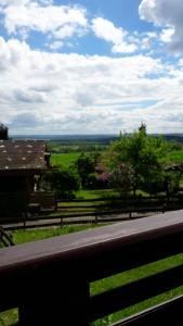 a fence with a view of a field and a house at Gemütliches Blockhaus im Harz in Bad Sachsa