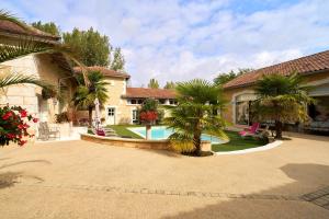 a house with a swimming pool in a yard at Chambres d'hôtes Le Pré Fleuri in Saint-Sulpice-de-Roumagnac