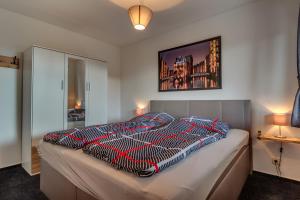 a bedroom with a bed with a comforter on it at Gemütliches Blockhaus im Harz in Bad Sachsa