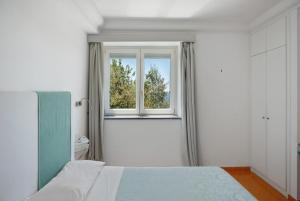 a bedroom with a bed and a window at Suite Tramonto in dependance in Conca dei Marini