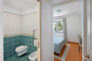 a bathroom with a toilet and a bed at Suite Tramonto in dependance in Conca dei Marini +15 photos