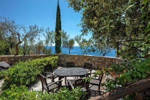 a table and chairs in a garden with a stone wall at Suite Tramonto in dependance in Conca dei Marini