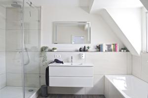a white bathroom with a sink and a shower at Hq16 - Modernes Ferienhaus in Neuenburg am Rhein +33 photos