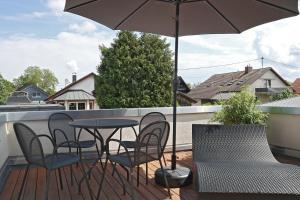a patio with a table and chairs and an umbrella at Hq16 - Modernes Ferienhaus in Neuenburg am Rhein