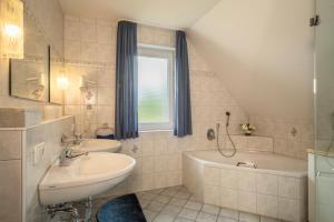 a bathroom with a sink and a bath tub at Ferienwohnung Haidle in Eriskirch