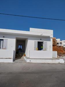 a white house sitting on the side of a street at I Have A Dream in Agia Pelagia