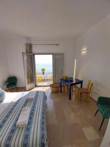 a bedroom with a bed and a table with a view of the ocean at I Have A Dream in Agia Pelagia
