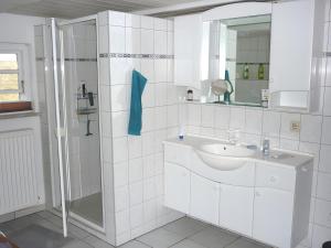 a white bathroom with a sink and a shower at Ferienhaus Osterdeich in Neukirchen +13 photos