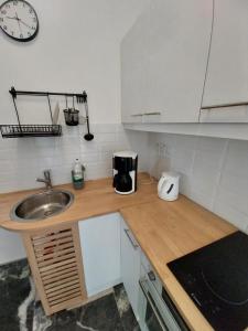 a kitchen counter with a sink and a clock on the wall at I Have A Dream in Agia Pelagia