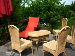 a group of chairs and a red chair on a patio at Ferienhaus Osterdeich in Neukirchen