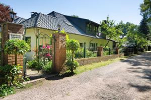 a yellow house with a gate and a fence at Im grünen Winkel in Brüggen