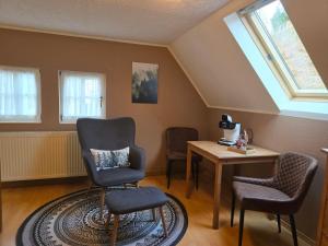 a room with a chair and a table and windows at Huthaus zum Molchner Stollen in Pobershau