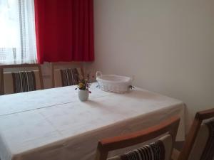 a white table with a vase with flowers on it at Haus Mühlgrund in Bad Wildbad