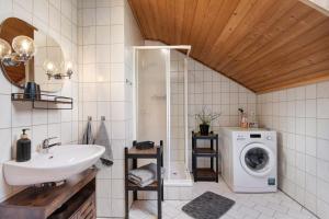 a bathroom with a sink and a washing machine at Ferienhäusl in Eschlkam