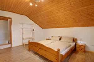 a bedroom with a bed with a wooden ceiling at Ferienhäusl in Eschlkam