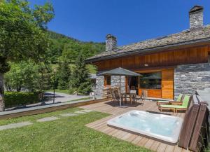a backyard with a hot tub on a wooden deck at Chalet Du Houx in Les Allues