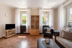 a living room with a couch and a tv at Ferienwohnung Andres in Briedern