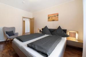 a bedroom with a large bed and a chair at Ferienwohnung Andres in Briedern
