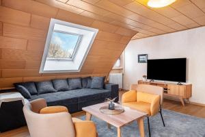 a living room with a couch and a tv at Haus Doktor Saeltzer in Lenzkirch