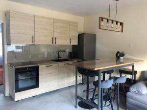 a kitchen with wooden cabinets and a wooden table with stools at Haus Milaneva in Klotten