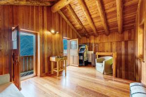a living room with wooden walls and a wooden floor at La Libellula in Scopello
