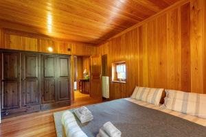 a bedroom with wooden walls and a bed and a couch at La Libellula in Scopello