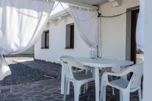 a white table and chairs on a patio at Prima Luce in SantʼAnna Arresi