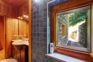 a bathroom with a sink and a glass window at La Libellula in Scopello +36 photos