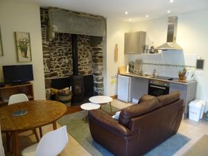 a living room with a couch and a table and a kitchen at Ensemble De Gites - Pen Ar Voas in Plestin-les-Grèves