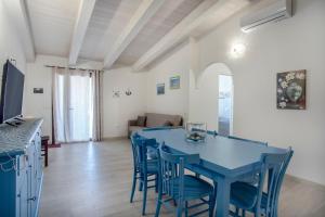 a kitchen and dining room with a blue table and chairs at Prima Luce in SantʼAnna Arresi