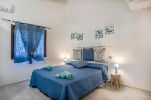 a bedroom with a blue bed with two towels on it at Prima Luce in SantʼAnna Arresi