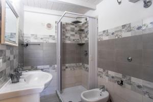 a bathroom with a shower and a sink and a toilet at Prima Luce in SantʼAnna Arresi
