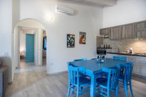 a kitchen with a blue table and blue chairs at Prima Luce in SantʼAnna Arresi +12 photos