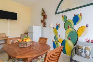 a dining room with a wooden table with fruit on it at Ciumara West in Avola