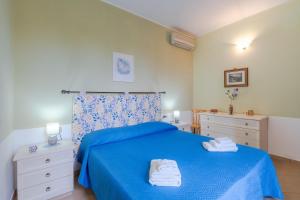 a bedroom with a blue bed with towels on it at Ciumara West in Avola