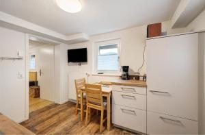 a kitchen with a table and a white refrigerator at Ferienwohnung Morgensonne in Wolfach