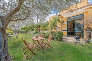 a table and chairs in the yard of a house at Ciumara West in Avola
