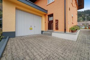a building with a white garage door and a brick driveway at Ferienwohnung Morgensonne in Wolfach
